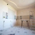 Cara memilih kontraktor renovasi rumah profesional sedang berdiskusi denah bangunan di lokasi proyek