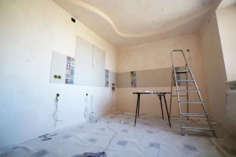 Cara memilih kontraktor renovasi rumah profesional sedang berdiskusi denah bangunan di lokasi proyek