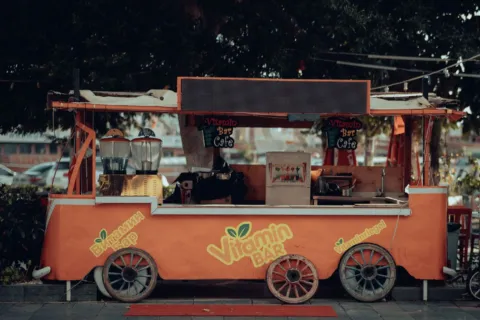 Penjual menyiapkan minuman di booth ide bisnis franchise modal kecil