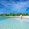 Pasangan menikmati pemandangan indah di destinasi honeymoon romantis tepi pantai