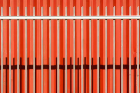Ide desain pagar rumah minimalis modern menggunakan kombinasi besi hollow hitam dan dinding semen kamprot abu-abu