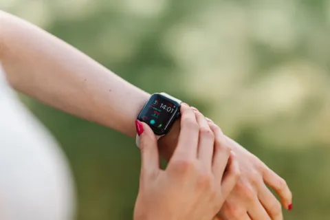 Seseorang sedang memilih smartwatch di toko elektronik sesuai kebutuhan aktivitas harian