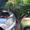Seorang pengemudi sedang memeriksa mesin untuk mengatasi mobil sulit dinyalakan di pinggir jalan