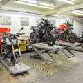 Mekanik sedang melakukan servis motor berkala pada bagian mesin di bengkel