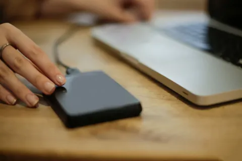 Seseorang sedang mempraktikkan cara backup data hp dengan mudah ke laptop menggunakan kabel usb