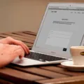 Pengusaha sedang menerapkan cara membuat website bisnis sendiri melalui laptop di meja kerja