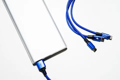 Tangan sedang menancapkan kabel charger ke port USB ponsel yang tidak bisa charge
