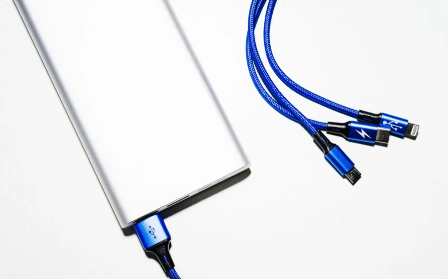 Tangan sedang menancapkan kabel charger ke port USB ponsel yang tidak bisa charge