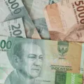 Ilustrasi perencanaan keuangan dengan cara mengatur budget liburan bulanan menggunakan aplikasi bank digital