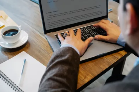 Pengusaha sedang mengecek dokumen legalitas dan cara mengurus izin usaha UMKM lewat laptop