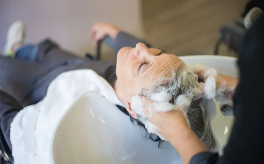 Seseorang sedang mengaplikasikan pembersih kulit kepala dalam panduan cara merawat rambut berketombe