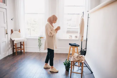 Padu padan ide outfit untuk konten media sosial dengan blazer dan kaos polos di studio rumah