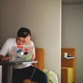Seseorang sedang mengetik di laptop untuk menjalankan kegiatan produktif saat menganggur di rumah