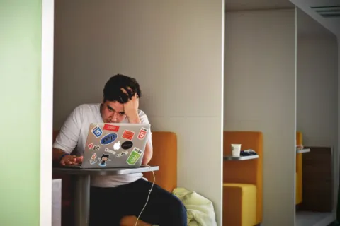 Seseorang sedang mengetik di laptop untuk menjalankan kegiatan produktif saat menganggur di rumah