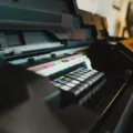 Seseorang sedang mencetak dokumen menggunakan printer ink tank hemat di meja kerja rumah