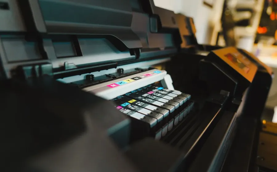 Seseorang sedang mencetak dokumen menggunakan printer ink tank hemat di meja kerja rumah