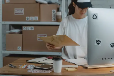 Seseorang sedang memantau pesanan pada laptop sebagai bagian tips memulai bisnis dropship