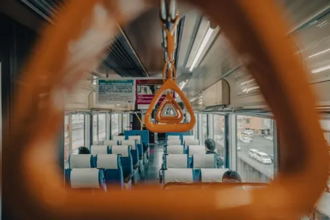 Penumpang menikmati pemandangan dari jendela gerbong sebagai cara traveling nyaman naik kereta api
